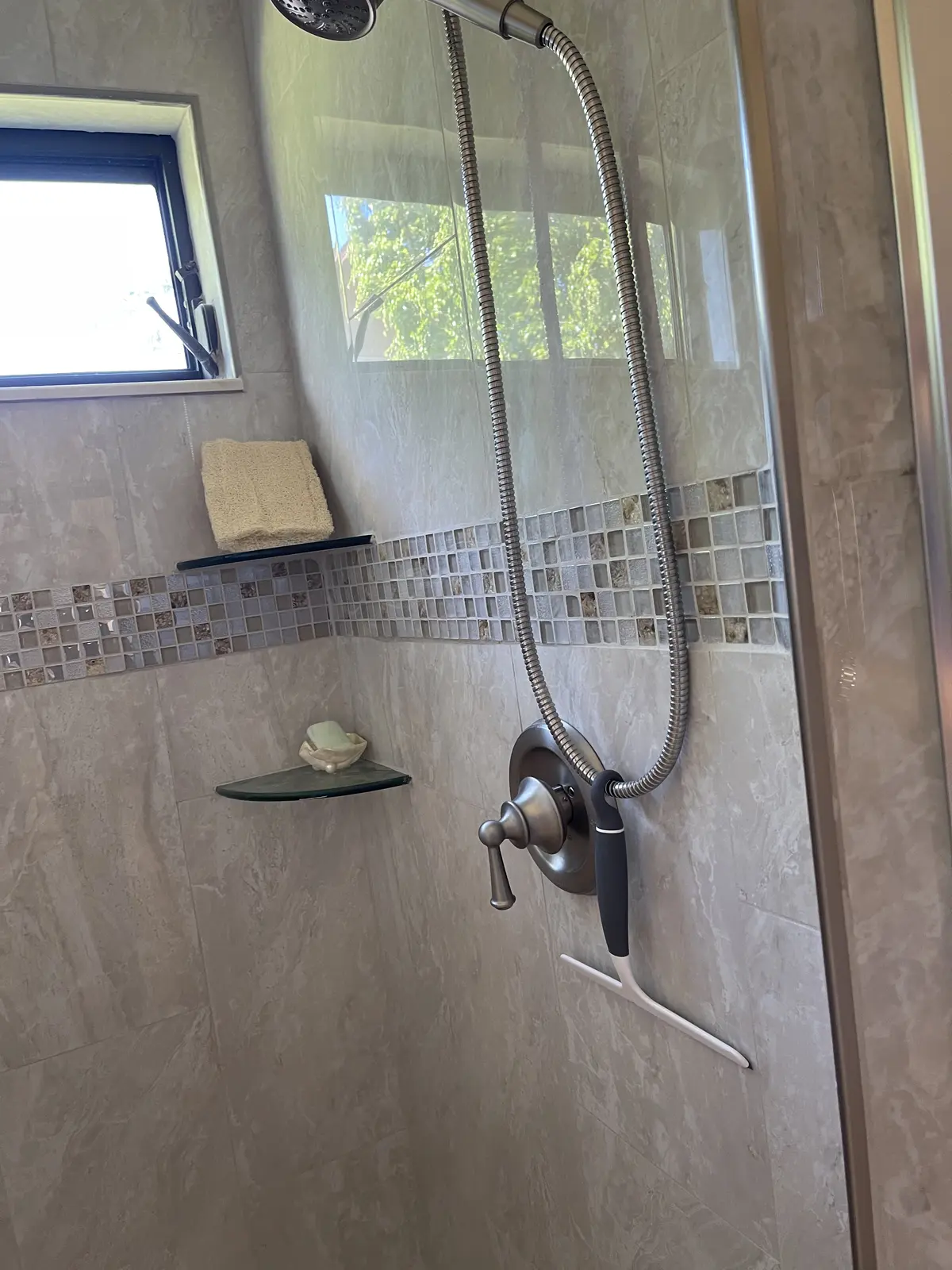 Completed Tampa bathroom remodel with tiled walk-in shower and glass enclosure