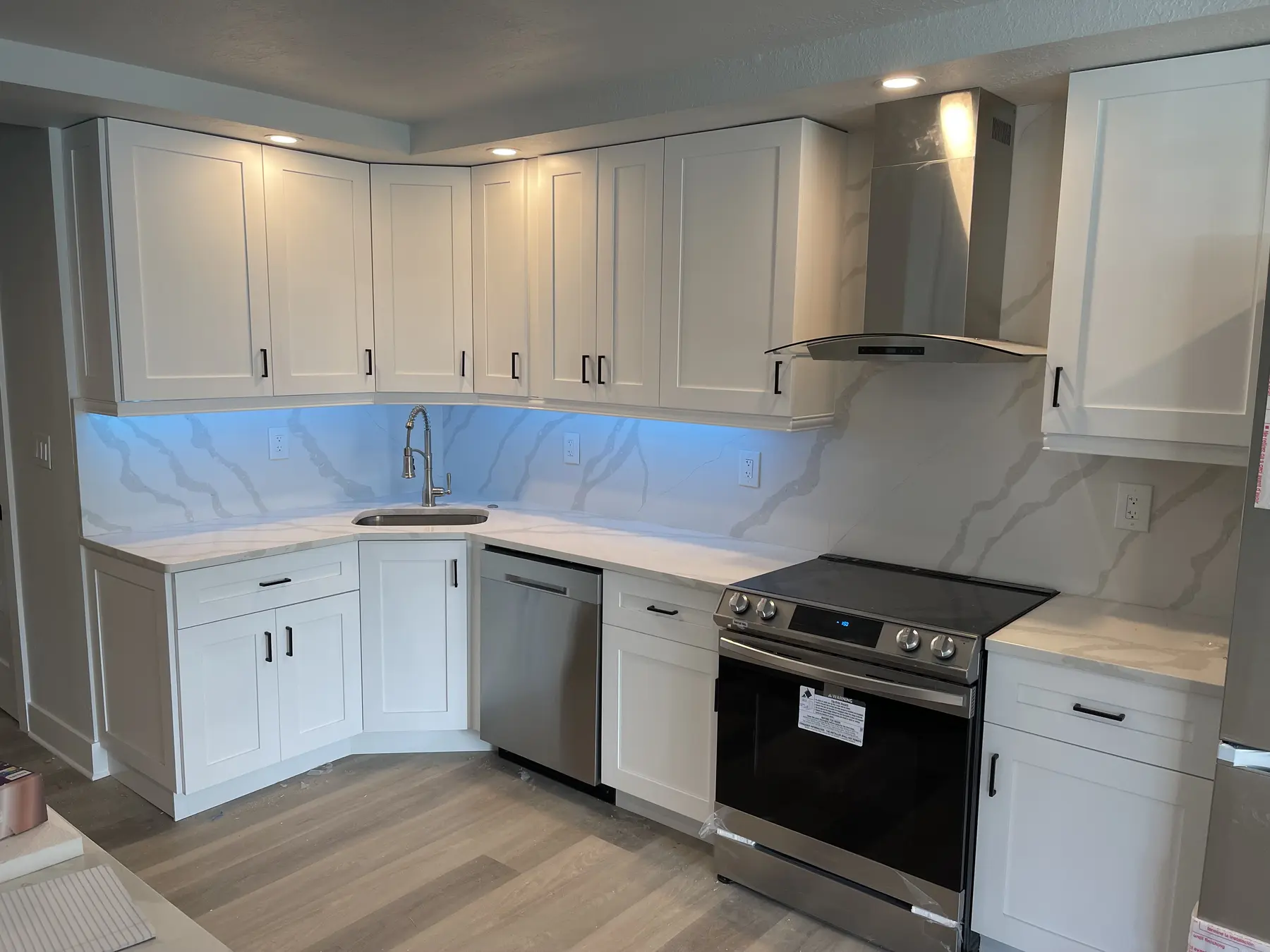 Completed kitchen and bathroom renovation with white cabinets and gray flooring