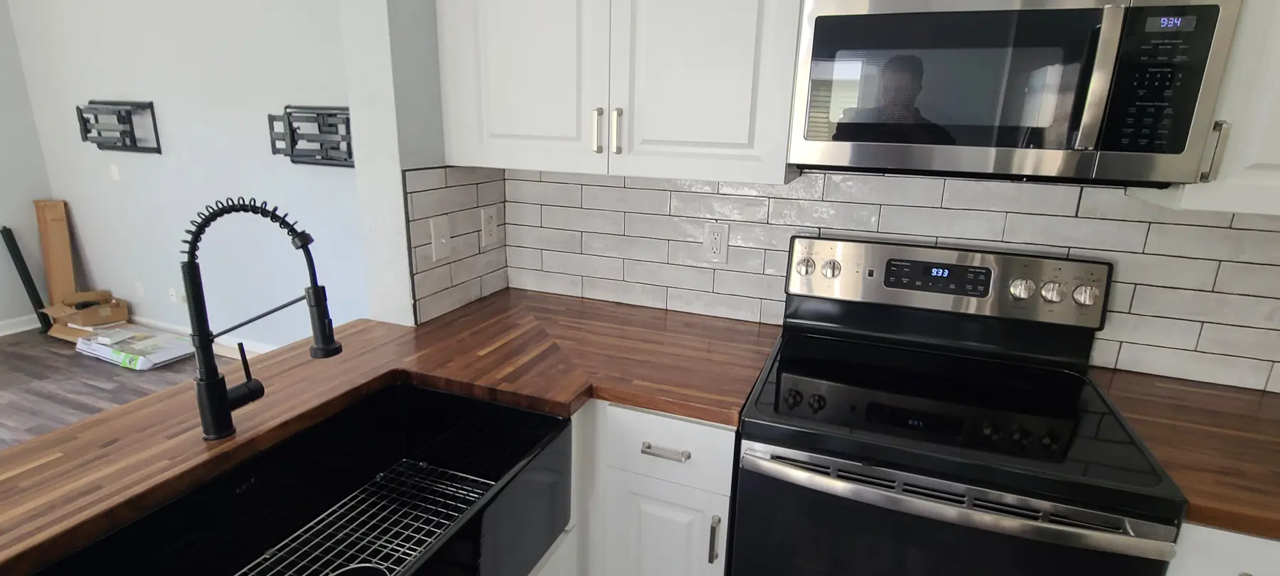 Finished butcher-block kitchen counters with white cabinetry and subway tile backsplash