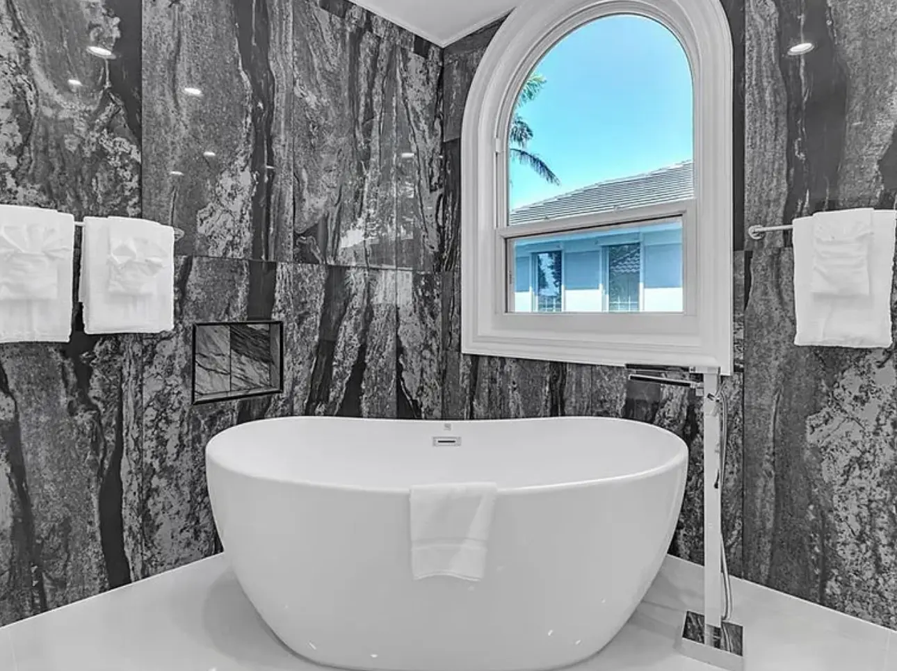 Completed Tampa primary bathroom with freestanding tub and coordinated stone-look wall