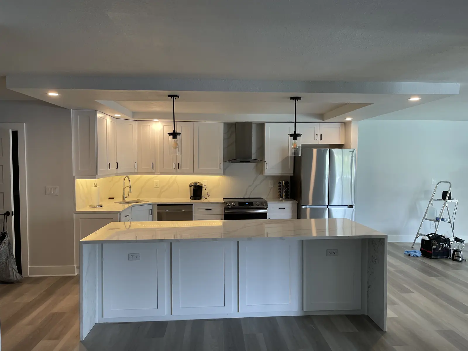 Open-concept Tampa kitchen renovation with white cabinets and peninsula seating